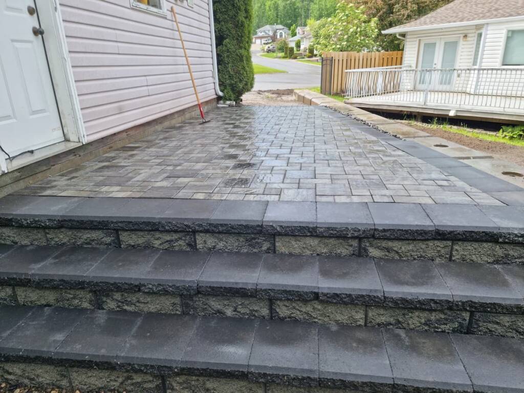 A high-end interlocking paving stone patio and matching walkway for a backyard landscape project in Prince George.