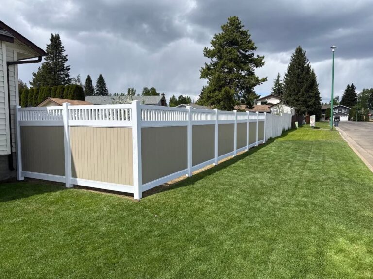 Low-maintenance two-tone vinyl fencing enclosing a spacious green yard and lawn on a Prince George residential street
